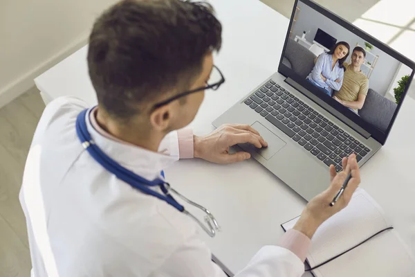 Nline medico parla con un paio di pazienti utilizzando un computer portatile . — Foto Stock