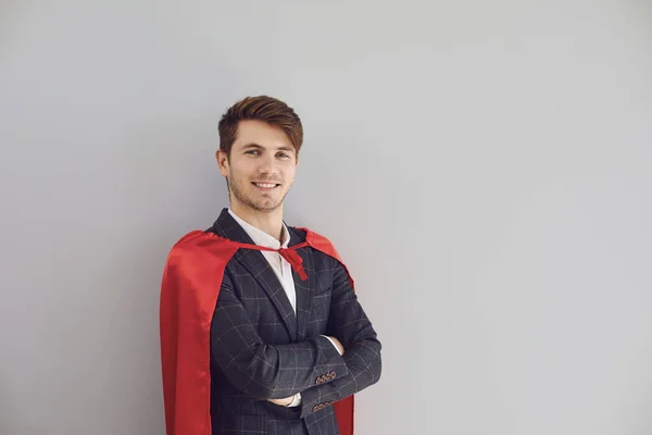 Homme heureux en costume de super-héros sourire sur fond gris. — Photo