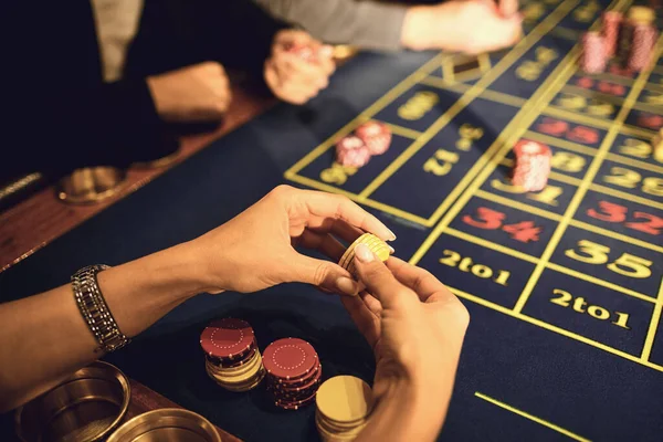 Fichas em uma mão de jogador de jogo em uma mesa em um cassino . — Fotografia de Stock