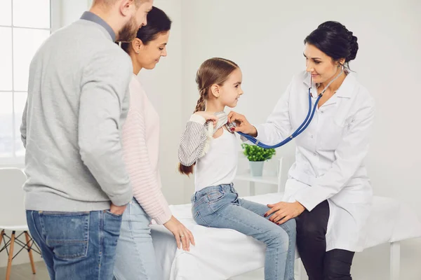 Gelukkige familie bij een bezoek aan de arts in het kantoor van een arts. — Stockfoto