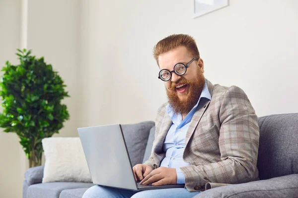 Pracujte online v domácí kanceláři. Vtipný tlustý muž pracuje pomocí notebooku v pokoji apartmánu. — Stock fotografie