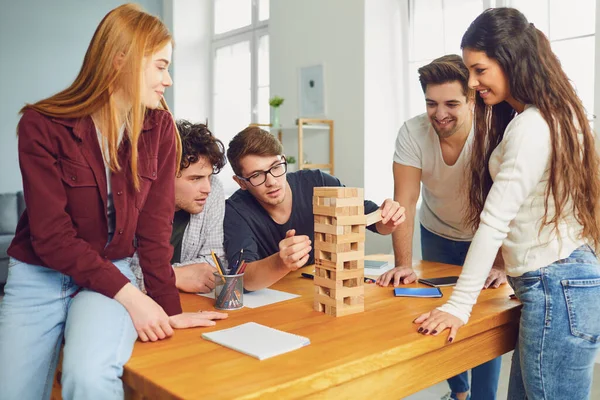 Jongeren hebben plezier met bordspelen aan een tafel in de kamer. — Stockfoto