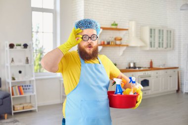 Önlüklü ve sarı eldivenli komik şişman adam odayı temizliyor..