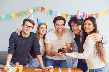 Doğum günün kutlu olsun. Pastalı bir grup arkadaş adama mutlu yıllar diliyor.