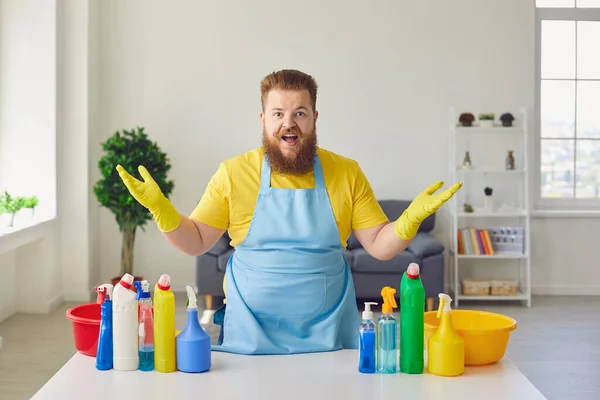穿着围裙和黄色清洁手套的胖男人在房间里打扫卫生. — 图库照片