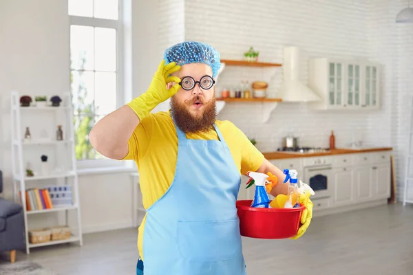 穿着围裙和黄色清洁手套的胖男人在房间里打扫卫生. — 图库照片