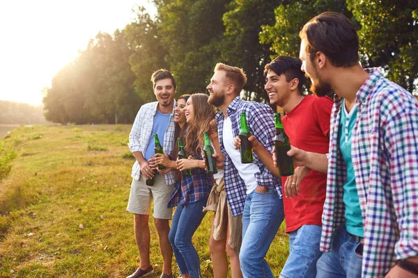 Young people drink and clink glasses at a picnic — Stock Photo, Image