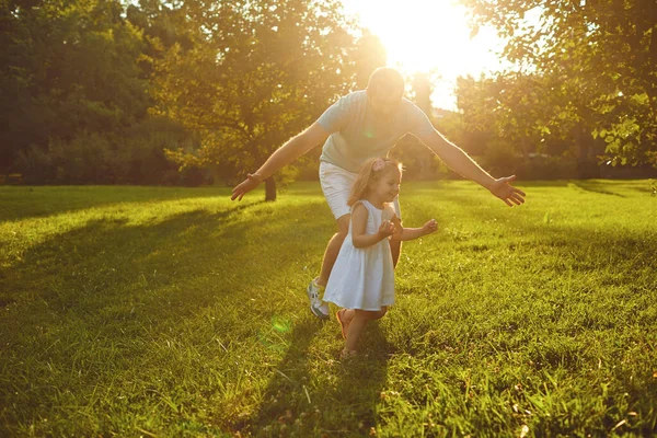 Fathers day. Father plays with his daughter in the summer park. — Stockfoto