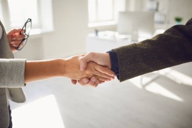 İş adamlarının el sıkışması. Kadın ve erkek el sıkışır ofiste..