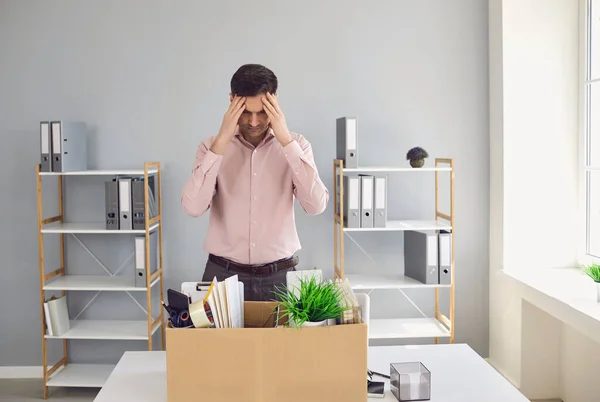 İşsizlik parası. Dağılabilirsiniz. İşten çıkarılan işadamı, şirket ofisinde otururken kafasını elinde tutan bir karton kutuya sinirlendi.. — Stok fotoğraf