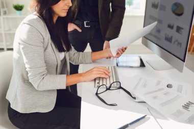 İş arkadaşlarıyla birlikte laptopta evraklarla çalışan ekin işçisi.