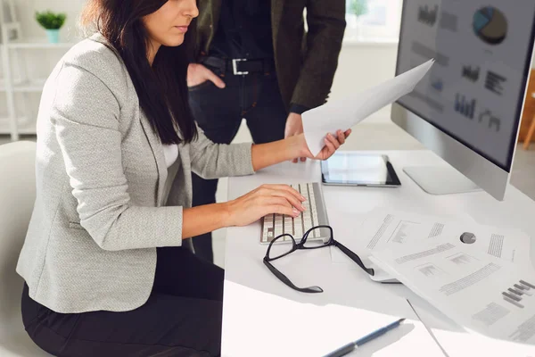 Mulher de negócios de colheita com colegas de trabalho trabalhando no laptop com papéis — Fotografia de Stock