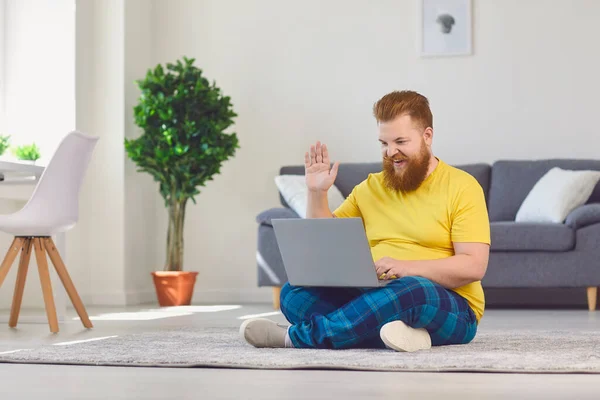 Online školení o práci. Vtipný muž s plnovousem pracující doma v laptopu — Stock fotografie
