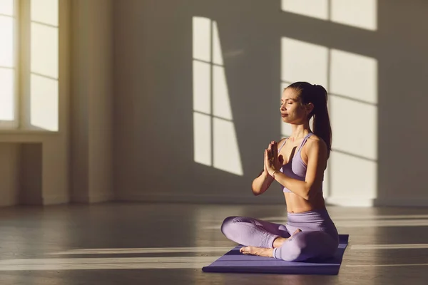 Mujer chica yoga en posición de loto se relaja en la mañana al amanecer en la habitación . . — Foto de Stock