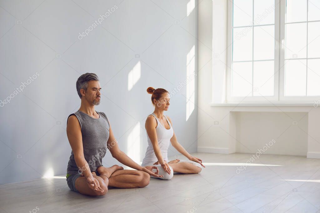 Yoga couple people hand sitting relaxation in lotus field on floor in studio class.