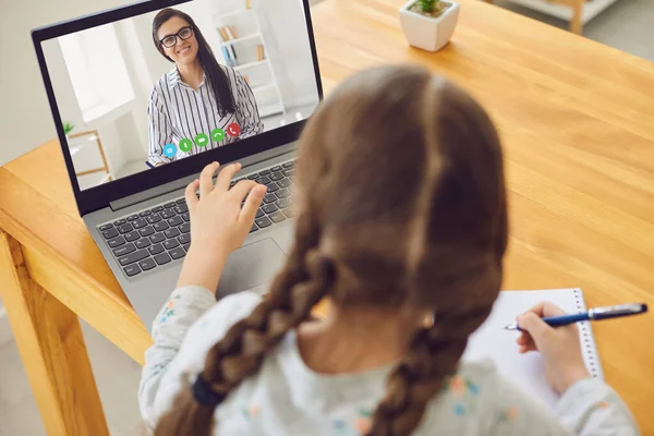Educação online de crianças. Menina estudante ensina uma lição on-line usando um laptop vídeo chat chamada conferência com um professor em casa . — Fotografia de Stock