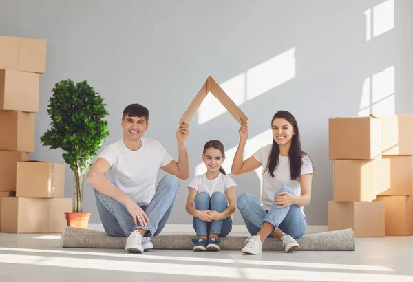 Lycklig familj med barn som flyttar in i ett nytt lägenhetshus. Mor far och dotter i ett nytt hus. — Stockfoto