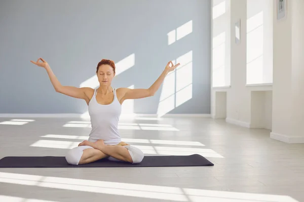 Yoga flicka. Fitness flicka utövar yoga i en lotusposition sitter i en studio — Stockfoto