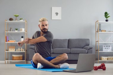 Spor egzersiz fitness çevrimiçi video çağrısı. Evdeki bilgisayarlı görüntülü sohbette ısınma egzersizleri yapan bir adam..