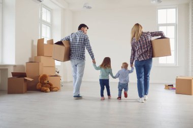 Mutlu ve çocuklu bir aile yeni bir apartmanda kutularla taşınıyor..