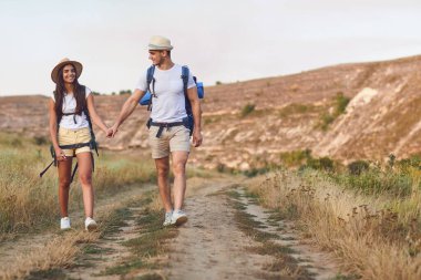 Hiking couple with backpack walking on hike in nature