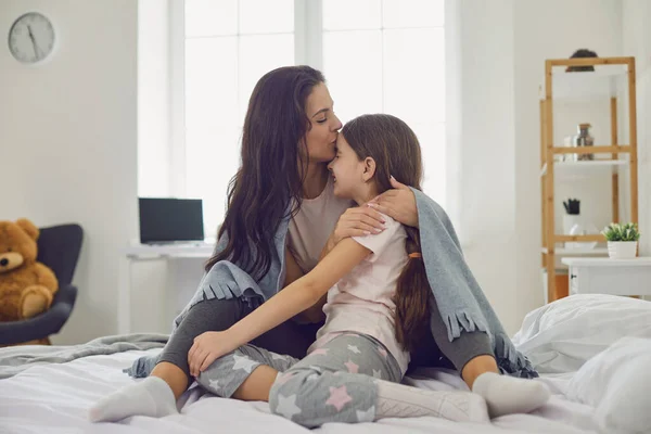 행복 한 엄마들. 어머니와 딸은 집 침대에 놓여 있는 화환으로 껴안고 있다 — 스톡 사진