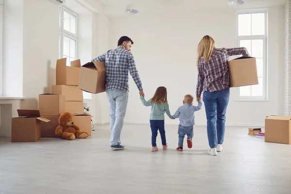 Glückliche Familie mit Kindern zieht mit Kisten in ein neues Mehrfamilienhaus. — Stockfoto