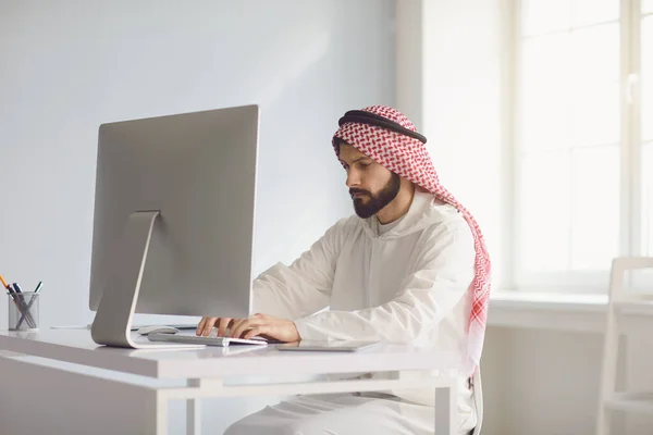 Арабский бизнесмен работает за компьютером на рабочем месте в офисе . — стоковое фото