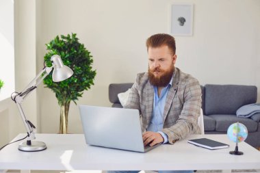 Evde internet işi. Ciddi şişman işadamı evde bilgisayarla eğitim iletişimi kuruyor..