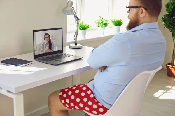 Online work at home. Funny fat businessman in red shorts works communicates video chat call using laptop in the room. — Stock Photo, Image