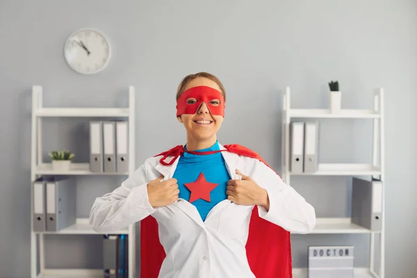Confident female doctor superhero in a hospital office. Medical protection of human health.