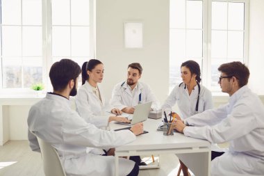 Bir grup doktor hastanenin ofisindeki masada oturuyorlar.