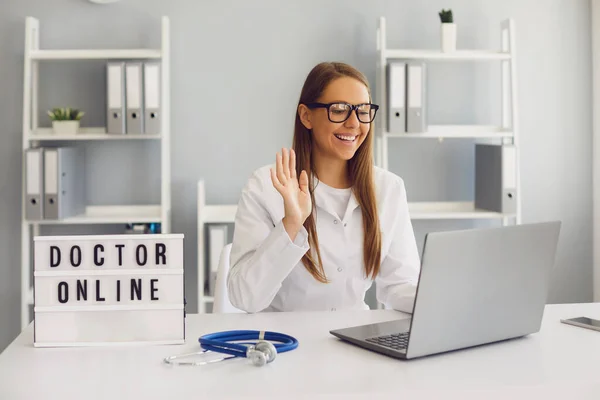Dottore e paziente online. Medico femminile con consultazione laptop diagnosi paziente video chat chiamata chat seduta sul posto di lavoro in clinica . — Foto Stock