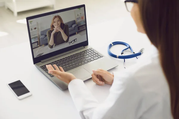 Lekarz i pacjent online. Kobieta lekarz z laptopem konsultacja diagnoza pacjenta wideo czat rozmowy siedząc w miejscu pracy w klinice. — Zdjęcie stockowe