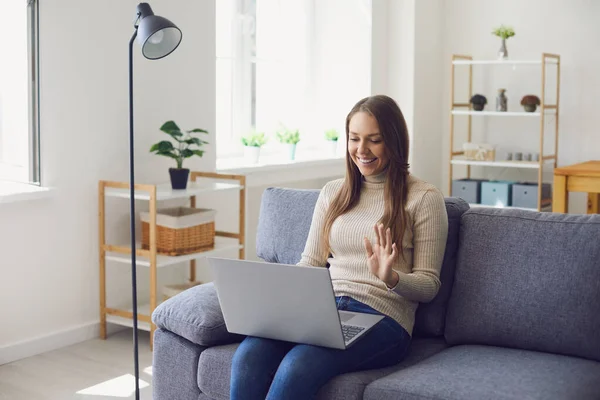Lavoro online a casa. Una donna lavora a un tavolo nell'utilizzo di un computer portatile parla con un partner attraverso l'applicazione di chat di videochiamata a casa . — Foto Stock