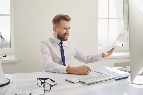 De sérieux documents de travail d'homme d'affaires occupé assis à une table avec un ordinateur dans le bureau . — Photo