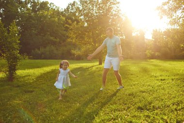 Fathers day. Father plays with his daughter in the summer park.