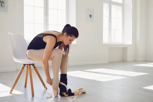 Balet baletowy. Młoda dziewczyna balerina sukienki pointe buty siedzi na krześle w studio. — Zdjęcie stockowe