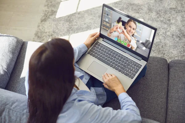 Familjen online. Mor talar med dotter med bärbar dator videosamtal sitter på soffan hemma. — Stockfoto