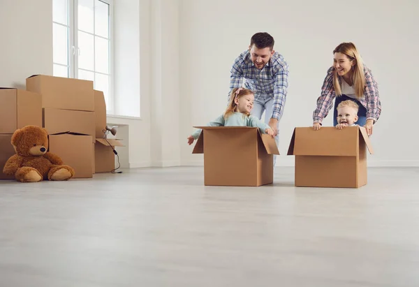 Familia feliz divertirse jugando en una nueva casa en la habitación. — Foto de Stock