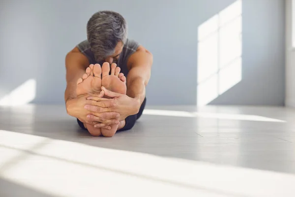 Yoga man. A man is practicing yoga balance in a gray room. — Stock Photo, Image
