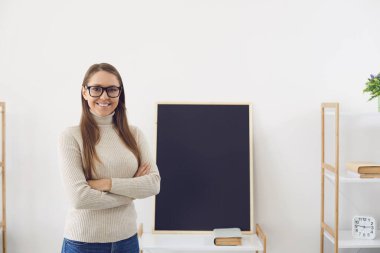 Çevrimiçi öğrenme. Gözlüklü bir öğretmen kameraya gülümsüyor. Görüntülü sohbet. Sınıftaki tahtada çağrı dersi..