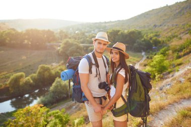 Romantic couple hikkers with backpacks on hikking the nature.