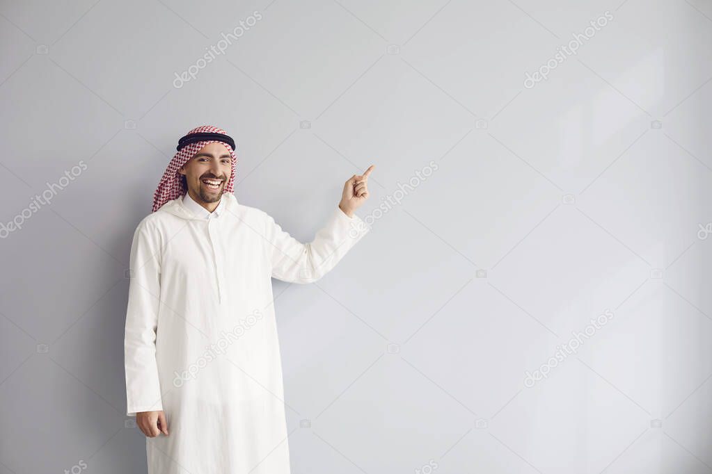 Arab male businessman points a finger to a gray background