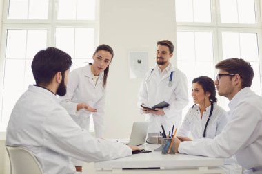Toplantıda bir grup doktor klinikte duran bir hastanın teşhisini tartışıyor..