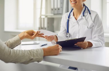 Yüzsüz doktor hastaya tıbbi bir reçete yazıyor..