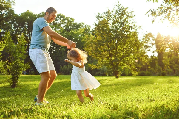 Fathers day. Father plays with his daughter in the summer park. — Stockfoto