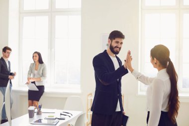 İş adamları, modern ofisteki işyerinde beş el mutlu bir gülümseme projesi sunuyor.