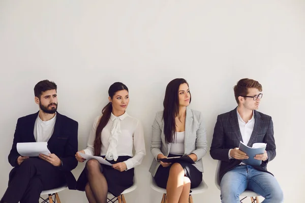 Gente de negocios esperando la contratación de una entrevista de trabajo sentados en una silla en la oficina. — Foto de Stock