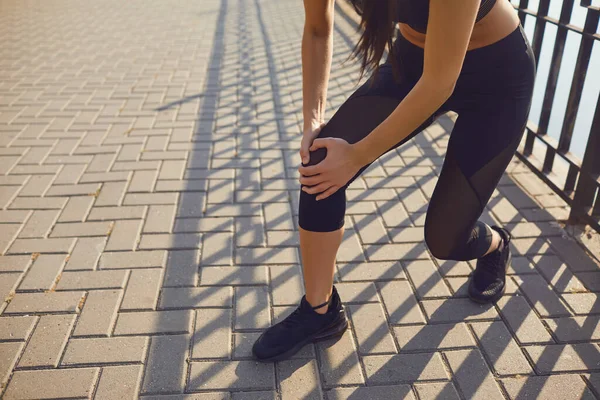 Knäskada i idrottaren flicka i parken. — Stockfoto